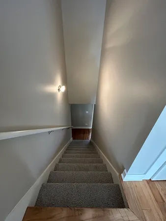 a view of a hallway with wooden floor and staircase