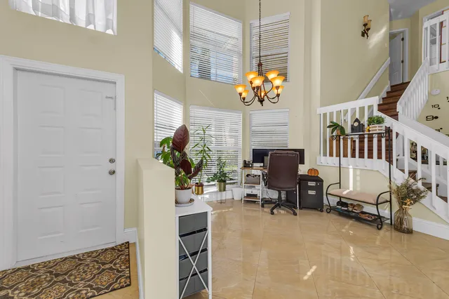 a living room with furniture flowerpot and a chandelier