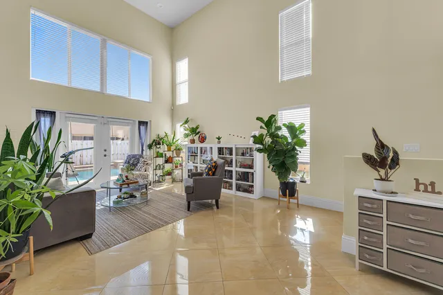 a living room with furniture potted plant and kitchen view