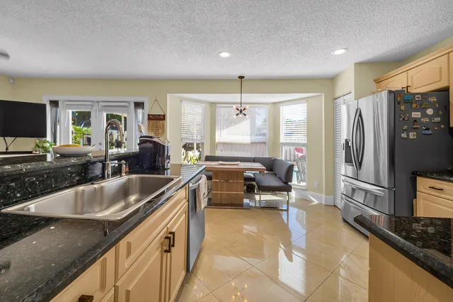 a kitchen with granite countertop a sink stove and refrigerator