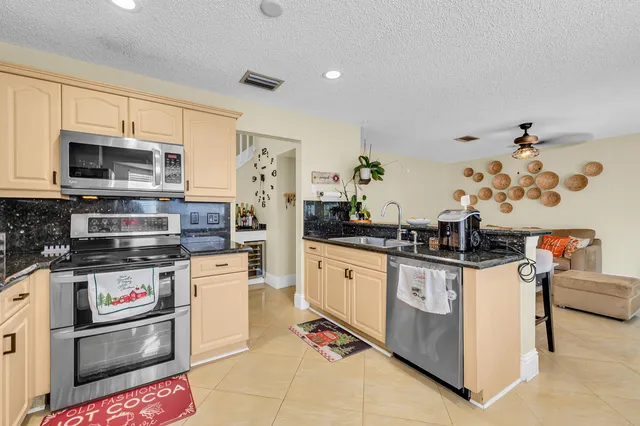 a kitchen with stainless steel appliances kitchen island granite countertop a stove and a sink