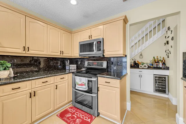 a kitchen with granite countertop a stove top oven microwave and cabinets