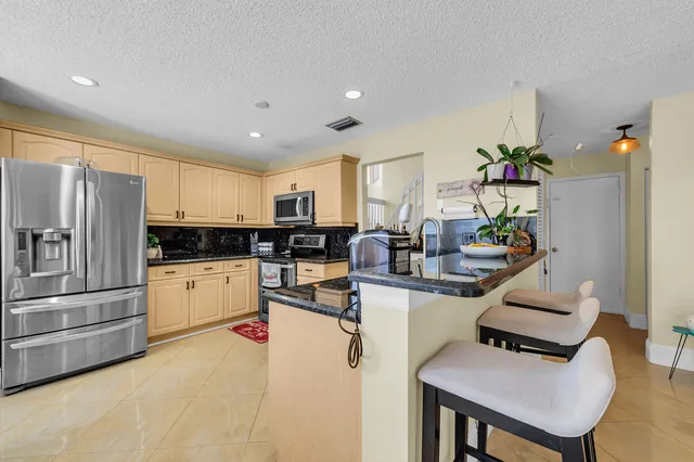 a kitchen with sink refrigerator and cabinets