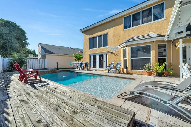 a view of a house with swimming pool and sitting area