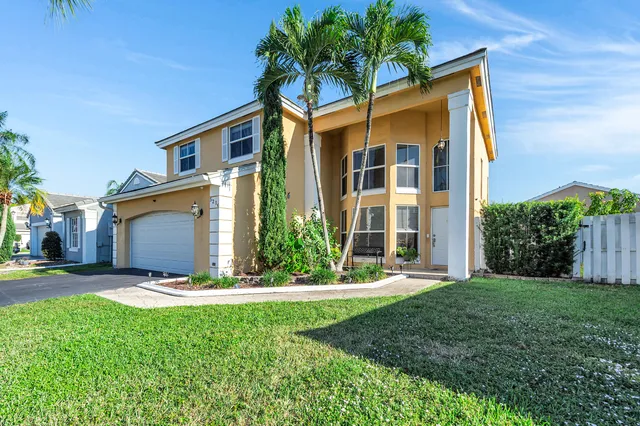 a view of a house with backyard and a tree