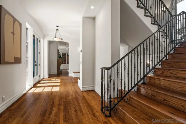 a view of a hallway with wooden floor and stairs