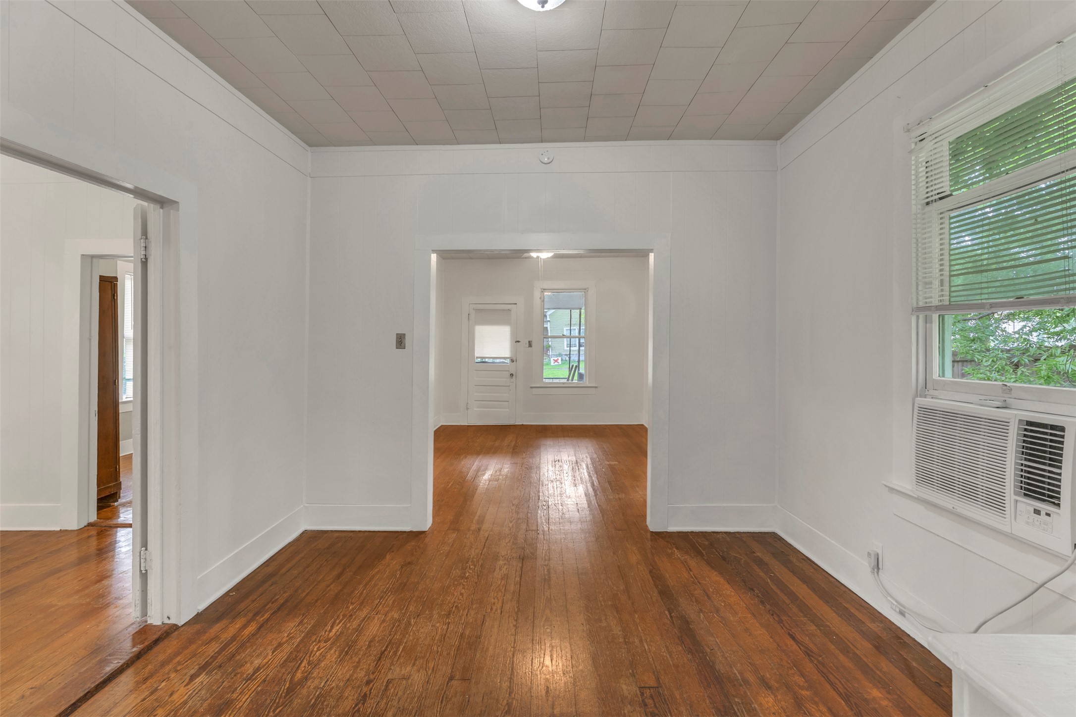 1002 Washburn Street Taylor, TX 76574 - Photo 11 of 29 This room features hardwood floors, white walls, and a window with an air conditioning unit