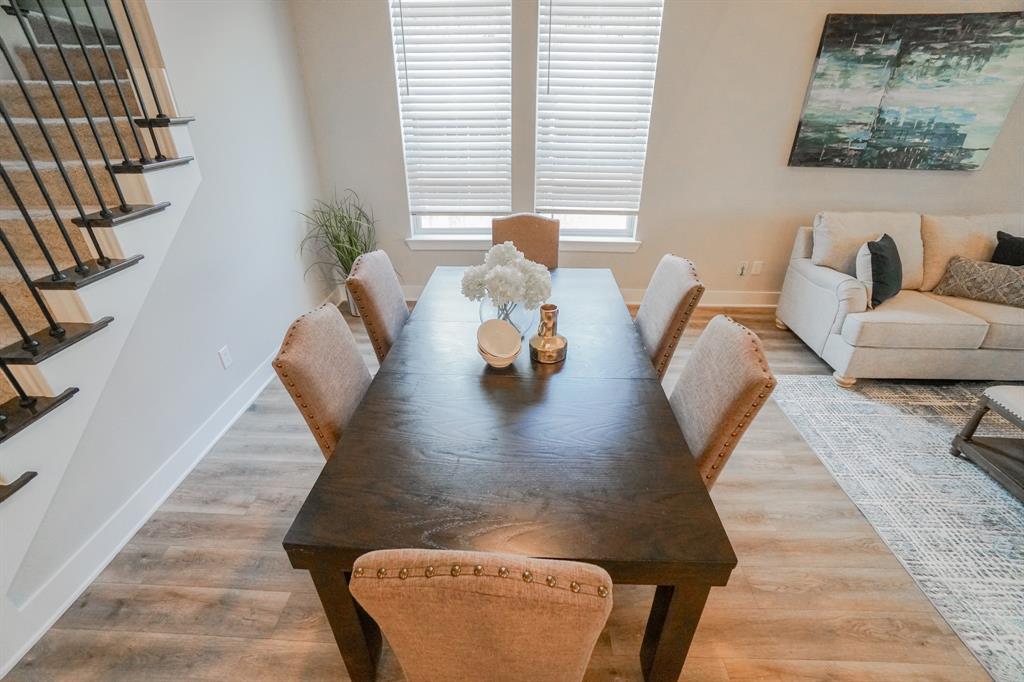 1309 Old Rocksprings Pass Mansfield, TX 76063 - Photo 6 of 36 Spacious interior featuring wood-finish flooring, a contemporary staircase with wrought iron balusters, and large windows with horizontal blinds