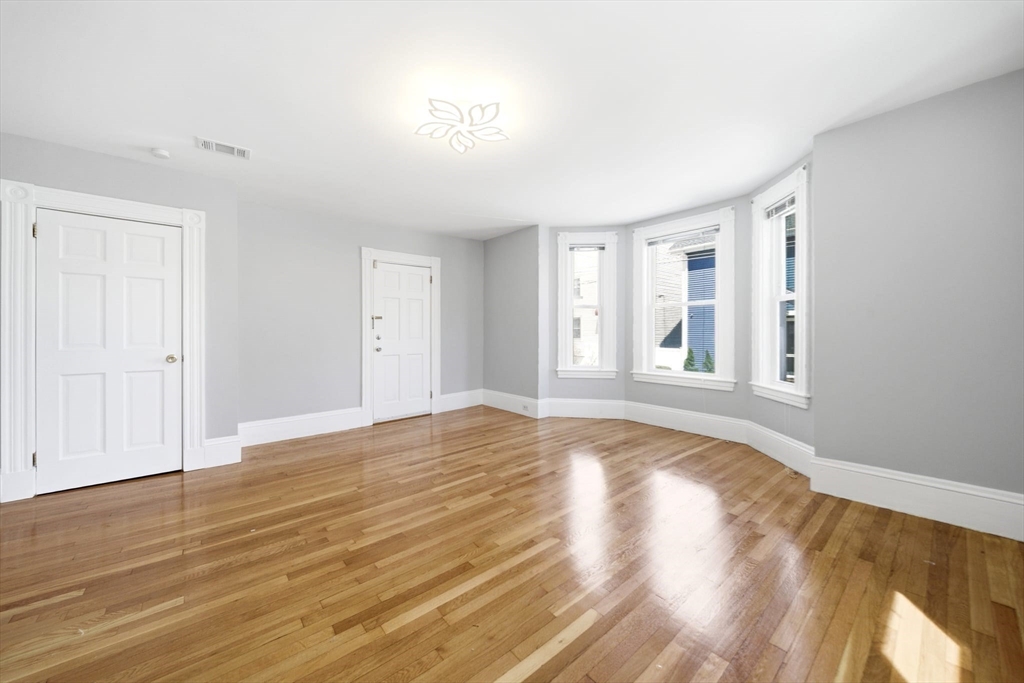 29 Hanson Street, Unit 1 Somerville, MA 02143 - Photo 11 of 40 a view of empty room with wooden floor and fan