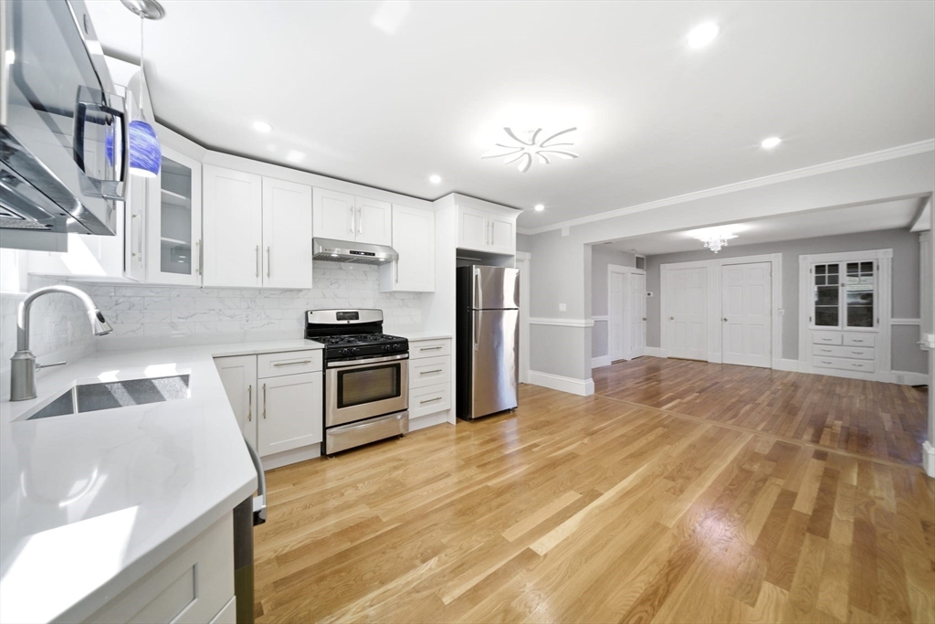 29 Hanson Street, Unit 1 Somerville, MA 02143 - Photo 19 of 40 a kitchen with granite countertop a sink cabinets and stainless steel appliances
