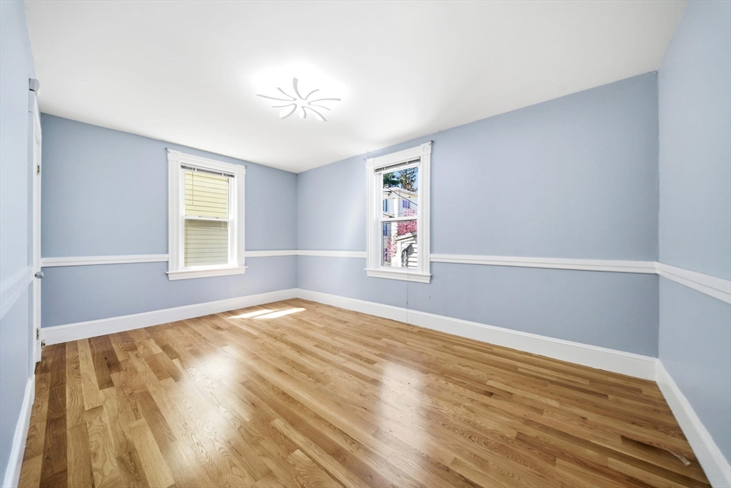 29 Hanson Street, Unit 1 Somerville, MA 02143 - Photo 23 of 40 a view of an empty room with wooden floor and a window