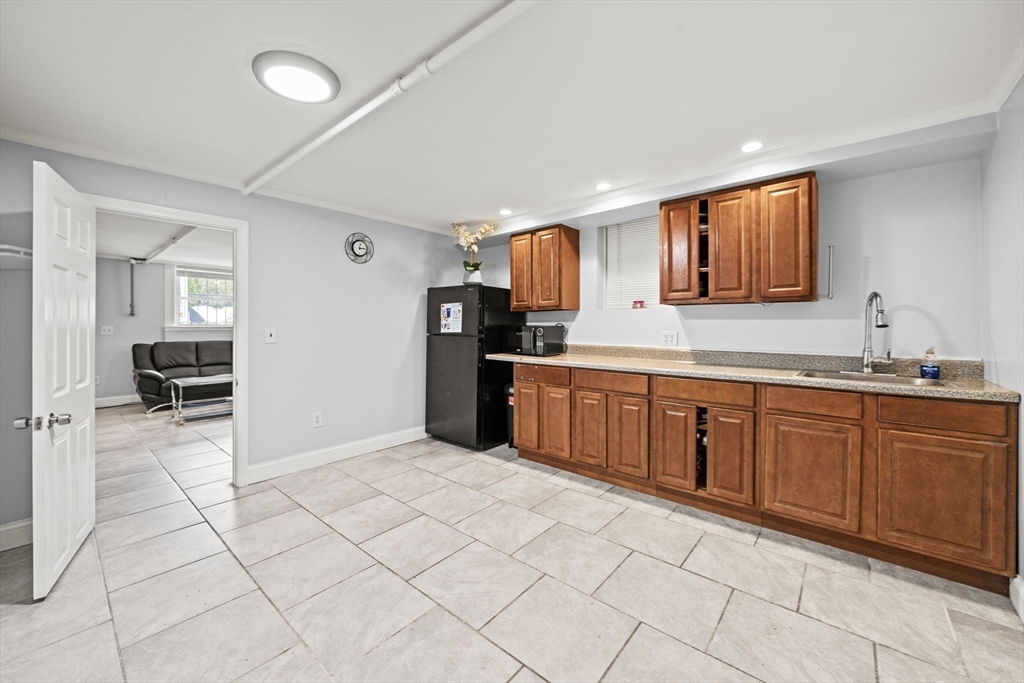 29 Hanson Street, Unit 1 Somerville, MA 02143 - Photo 31 of 40 a kitchen with stainless steel appliances a sink and a refrigerator