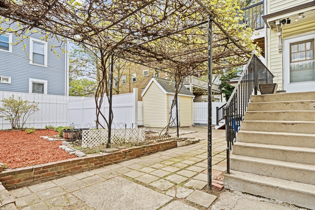 29 Hanson Street, Unit 1 Somerville, MA 02143 - Photo 5 of 40 a view of a brick house with large windows and a tree