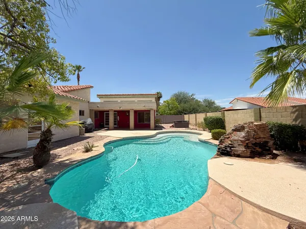 a view of a house with backyard sitting area and swimming pool