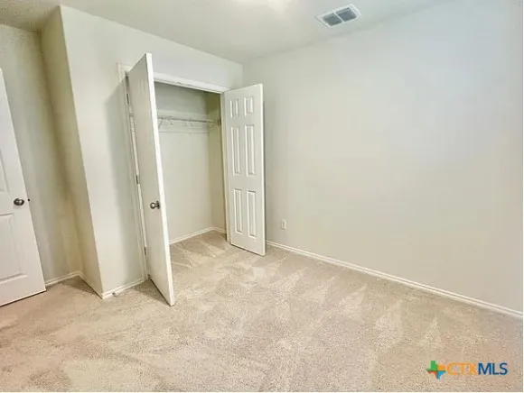 an empty room with closet and mirror