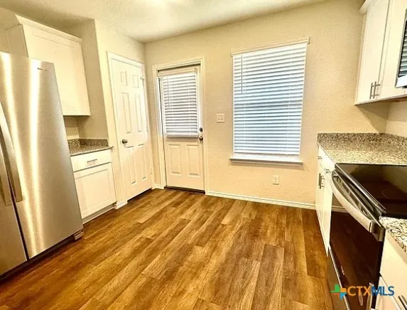 a kitchen with stainless steel appliances a refrigerator sink and cabinets
