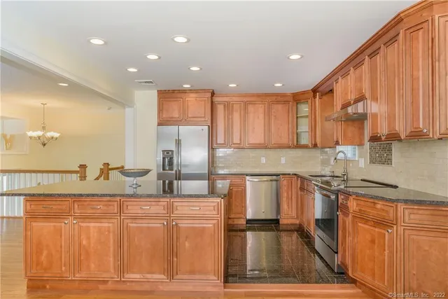 a kitchen with stainless steel appliances granite countertop a sink and cabinets