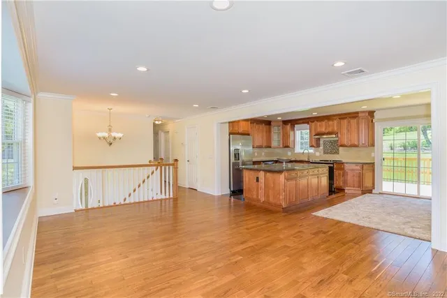 a large kitchen with stainless steel appliances granite countertop a large counter top a stove and a refrigerator
