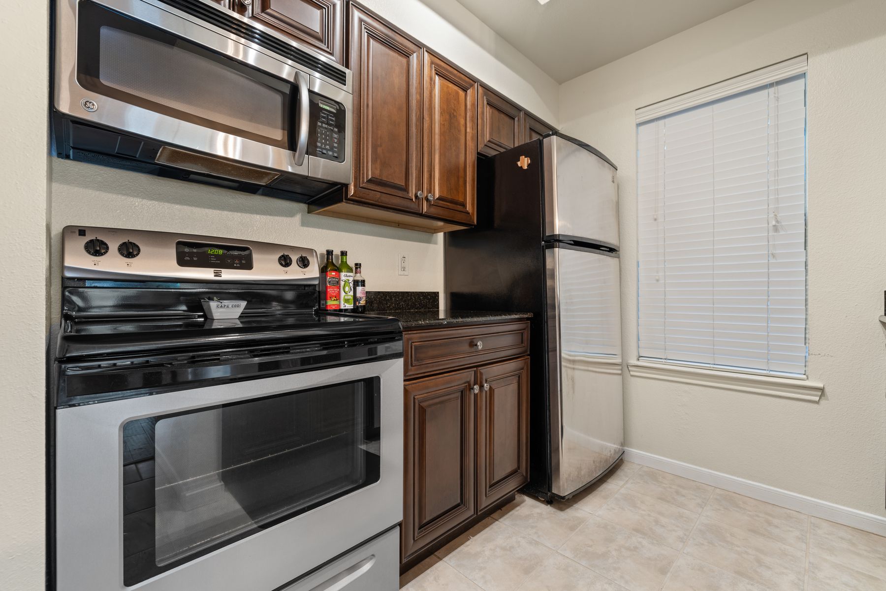 6000 Shepherd Mountain Cove, Unit 302 Austin, TX 78730 - Photo 11 of 22 a kitchen with stainless steel appliances granite countertop a stove and a microwave