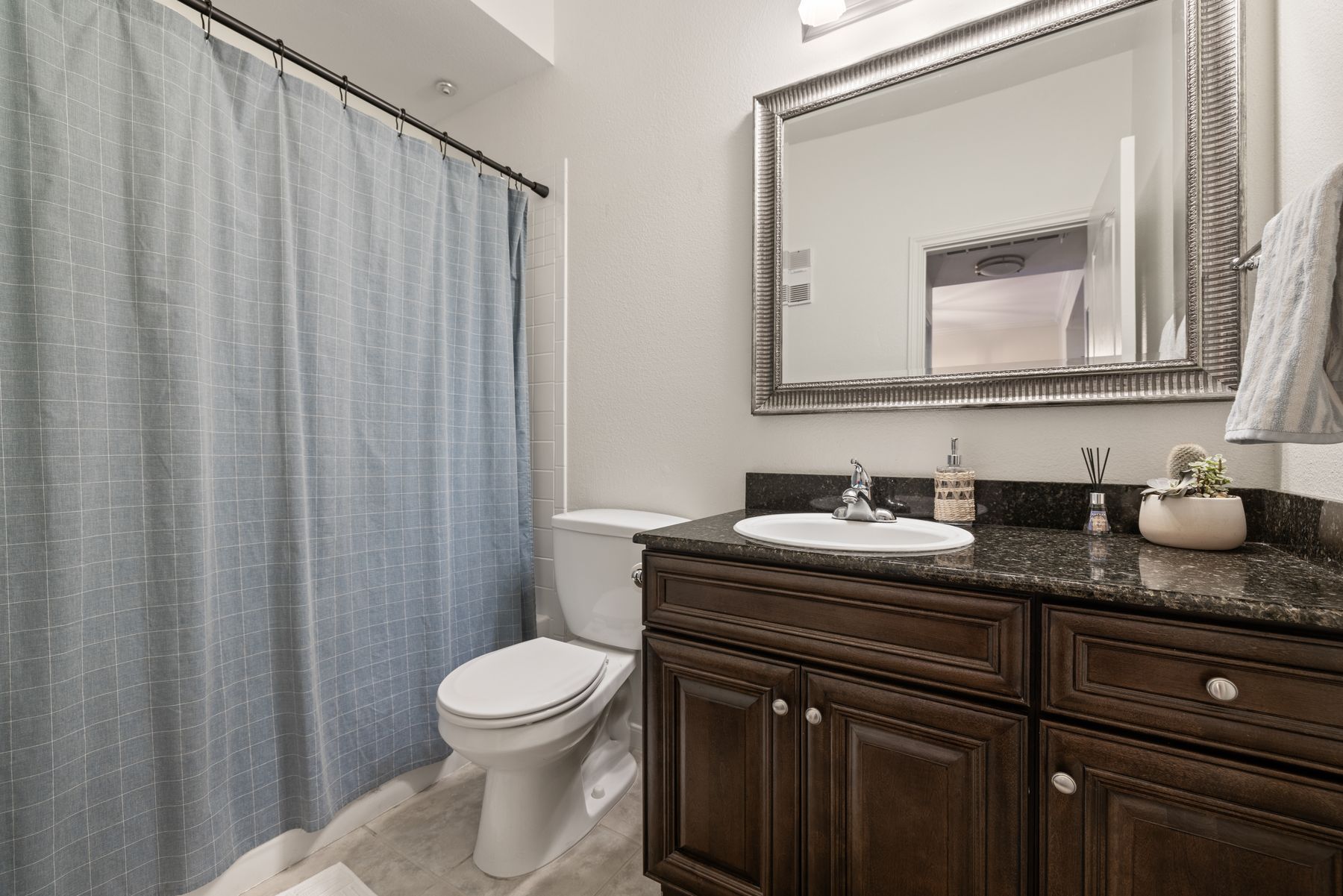 6000 Shepherd Mountain Cove, Unit 302 Austin, TX 78730 - Photo 20 of 22 a bathroom with a granite countertop sink a toilet and a mirror