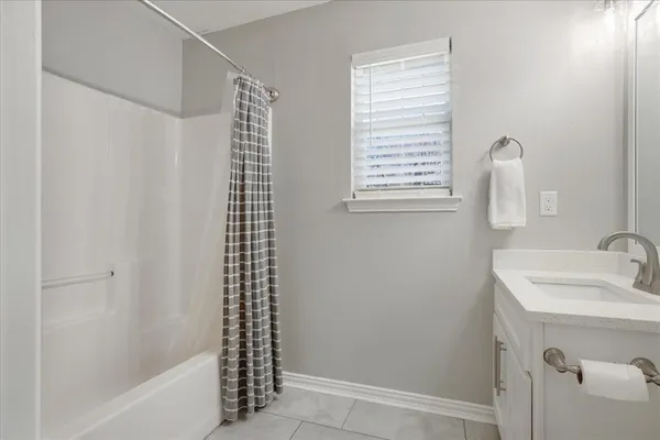 a bathroom with a shower curtain and a sink