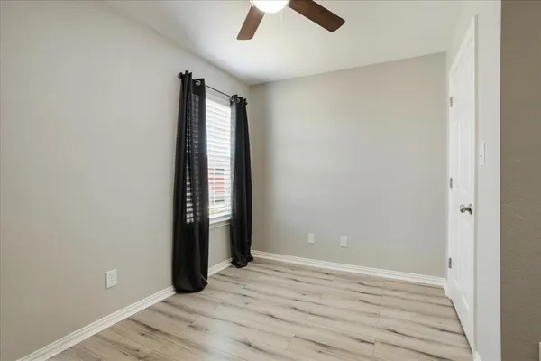 an empty room with closet and windows