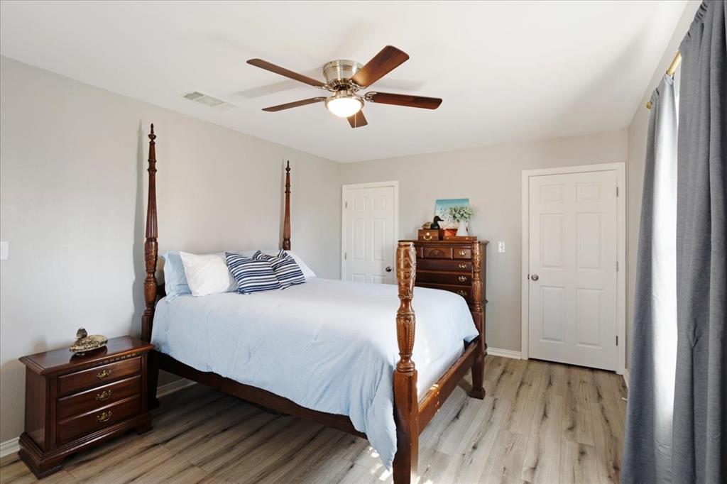 307 North Carter Street Howe, TX 75459 - Photo 20 of 31 a bedroom with a bed and a chandelier