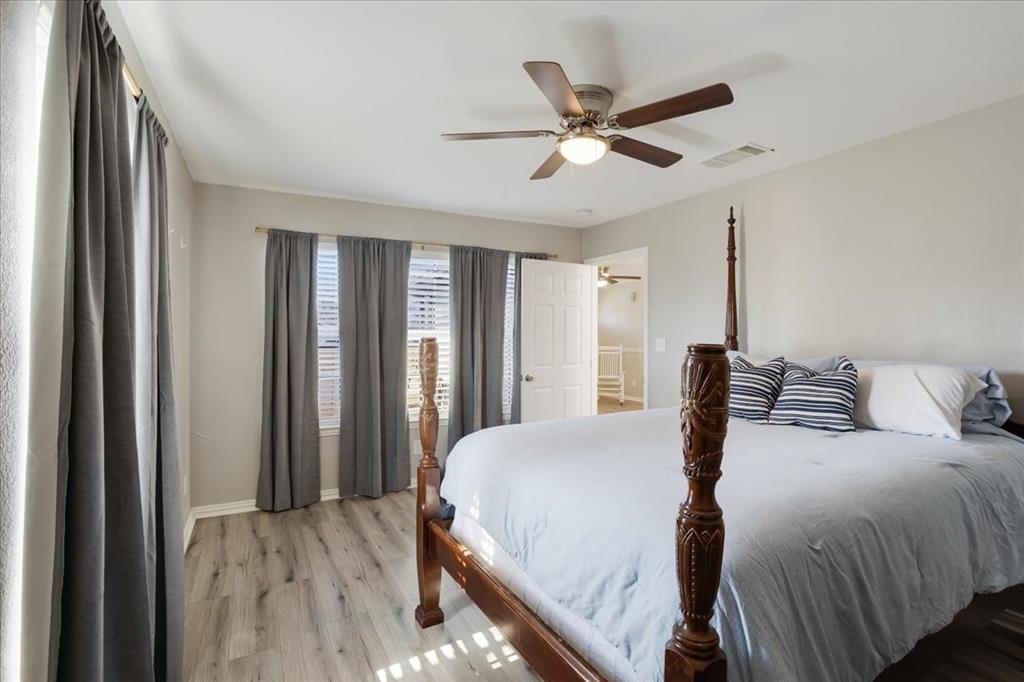 307 North Carter Street Howe, TX 75459 - Photo 21 of 31 a bedroom with a large bed and a chandelier