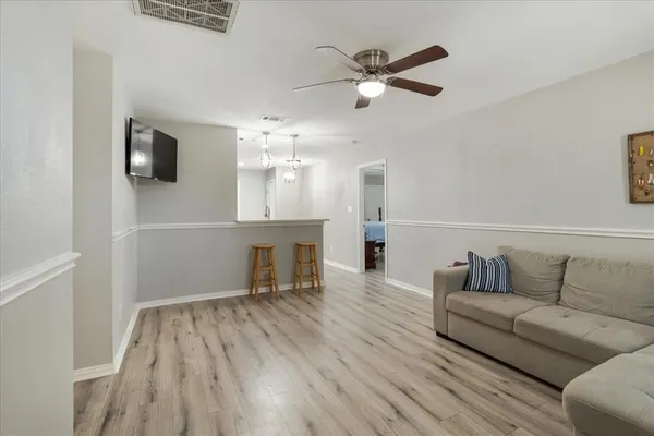 a living room with furniture and a wooden floor