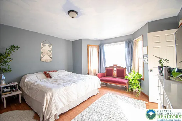 a bedroom with a bed chandelier and a window