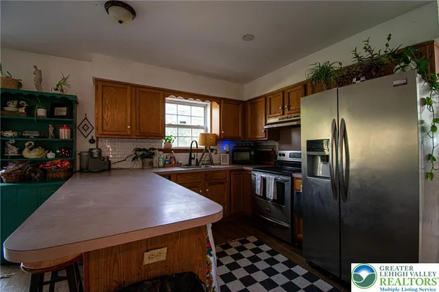 a kitchen with stainless steel appliances a refrigerator a stove a sink dishwasher and cabinets