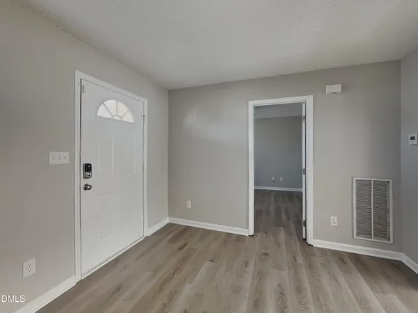 an empty room with wooden floor and closet