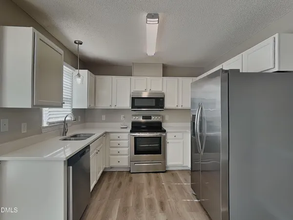 a kitchen with stainless steel appliances a refrigerator sink and cabinets