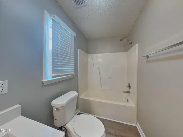 a white toilet sitting next to a bath tub shower