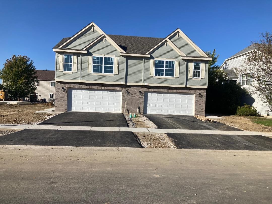 931 Saddle Ridge Drive Joliet, IL 60432 - Photo 2 of 23 a front view of a house with a yard and garage