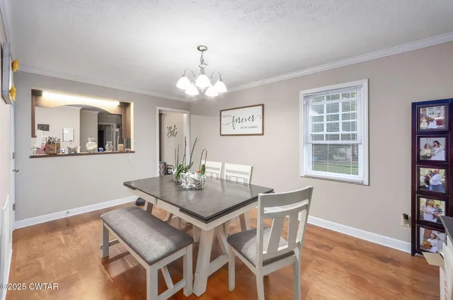 a view of a dining room with furniture and chandelier