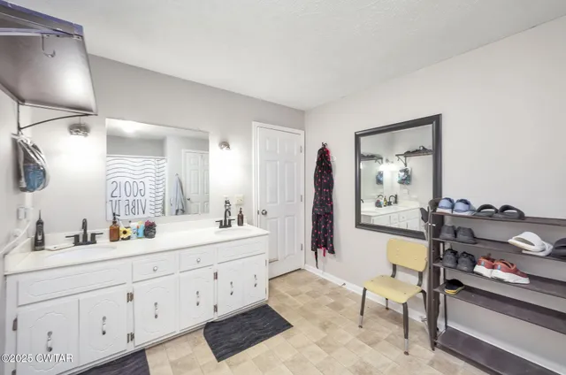 a en suite bathroom with a double vanity sink a mirror and a