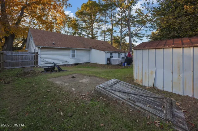 a view of a house with a backyard and a tree