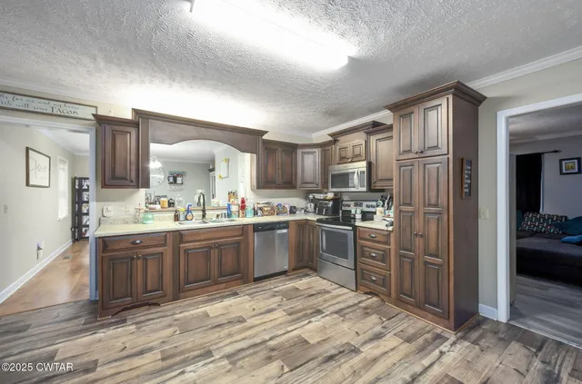 a large kitchen with kitchen island a sink stainless steel appliances and cabinets