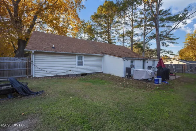a view of a backyard with furniture and a fire pit