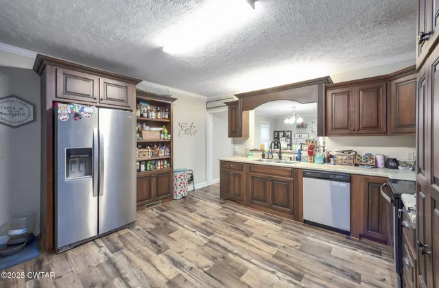 a kitchen with stainless steel appliances granite countertop a refrigerator and a stove top oven