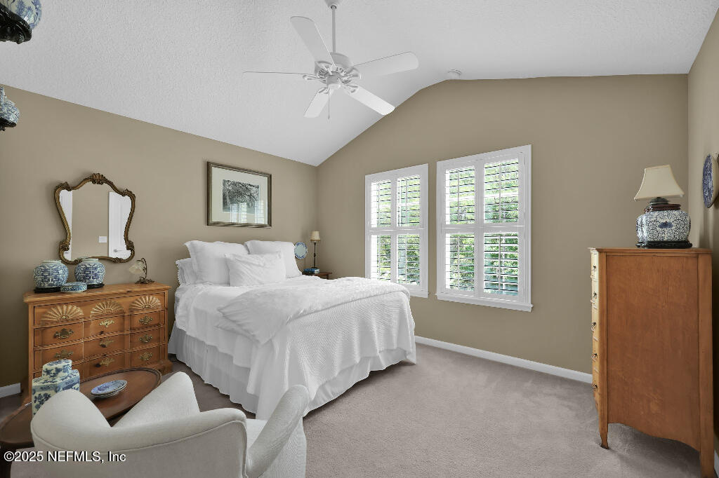 1922 North Loop Parkway St. Augustine, FL 32095 - Photo 16 of 23 a bedroom with a bed couches and chandelier