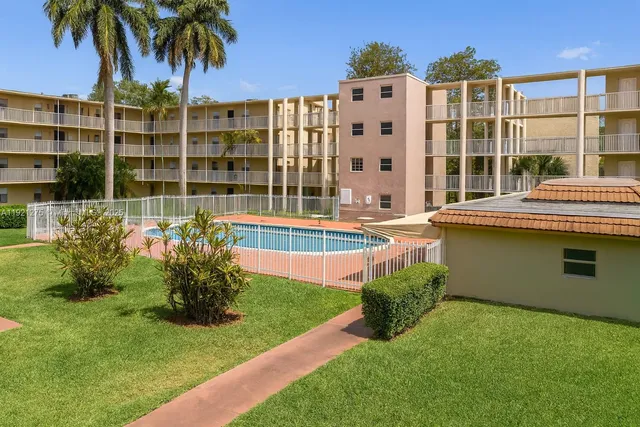 a front view of a building with a garden and plants