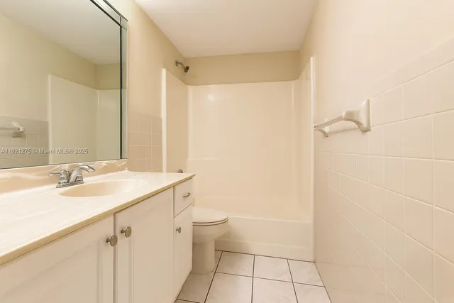 a bathroom with a granite countertop sink a toilet and a mirror