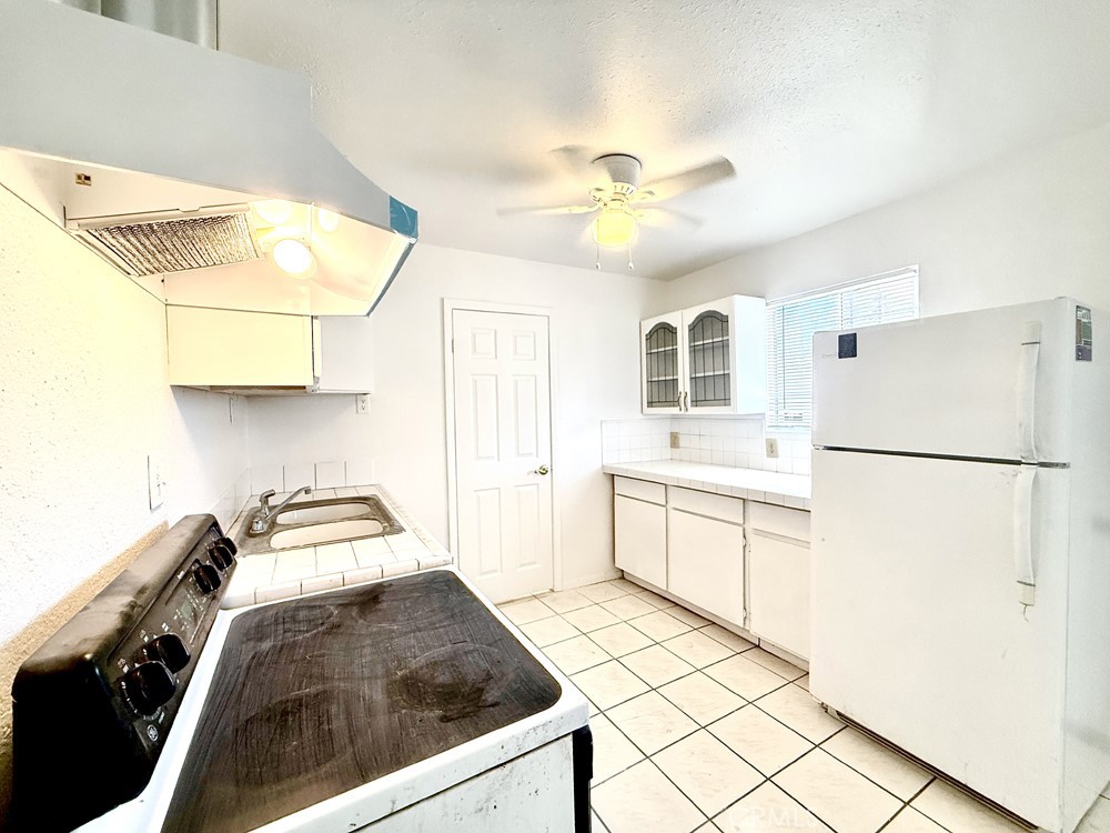 974 Grand Colton, CA 92324 - Photo 4 of 9 a kitchen with a refrigerator and white cabinets