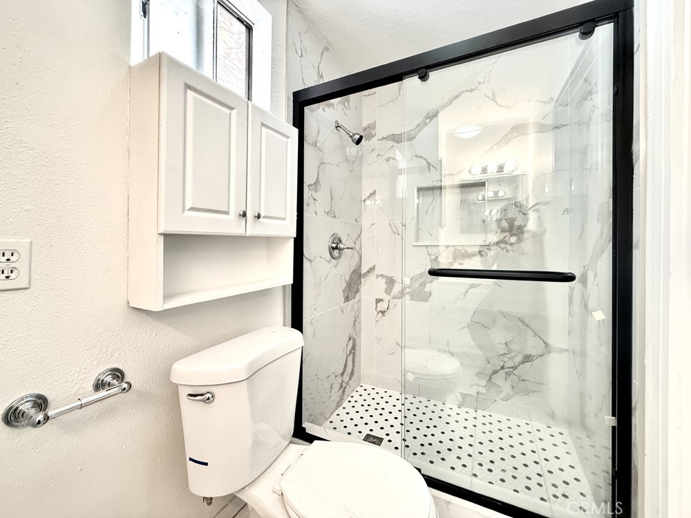 974 Grand Colton, CA 92324 - Photo 6 of 9 a bathroom with a shower toilet and a window