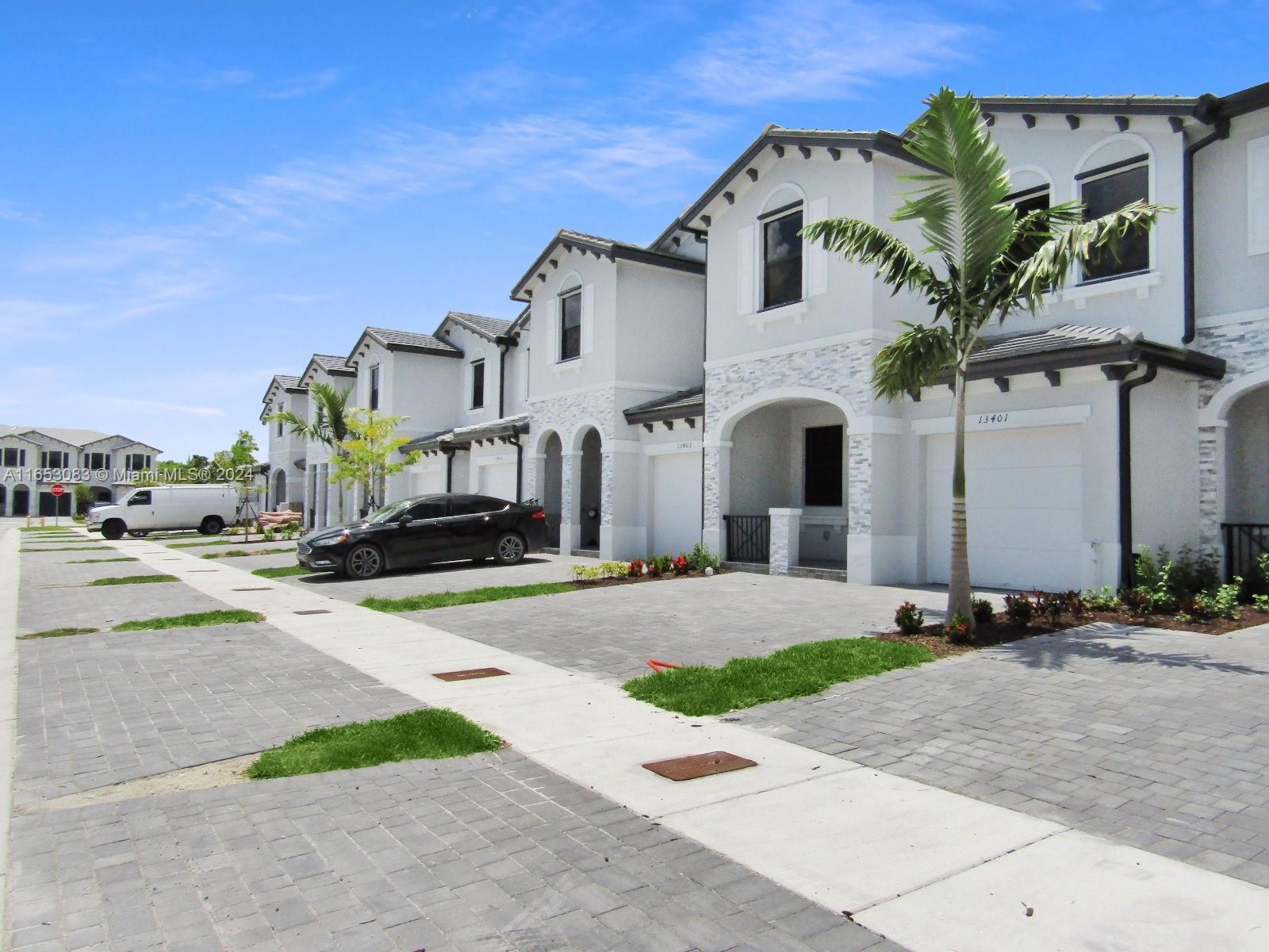 13401 Southwest 287th Street, Unit 13401 Homestead, FL 33033 - Photo 2 of 29 a front view of a house with a yard and garage