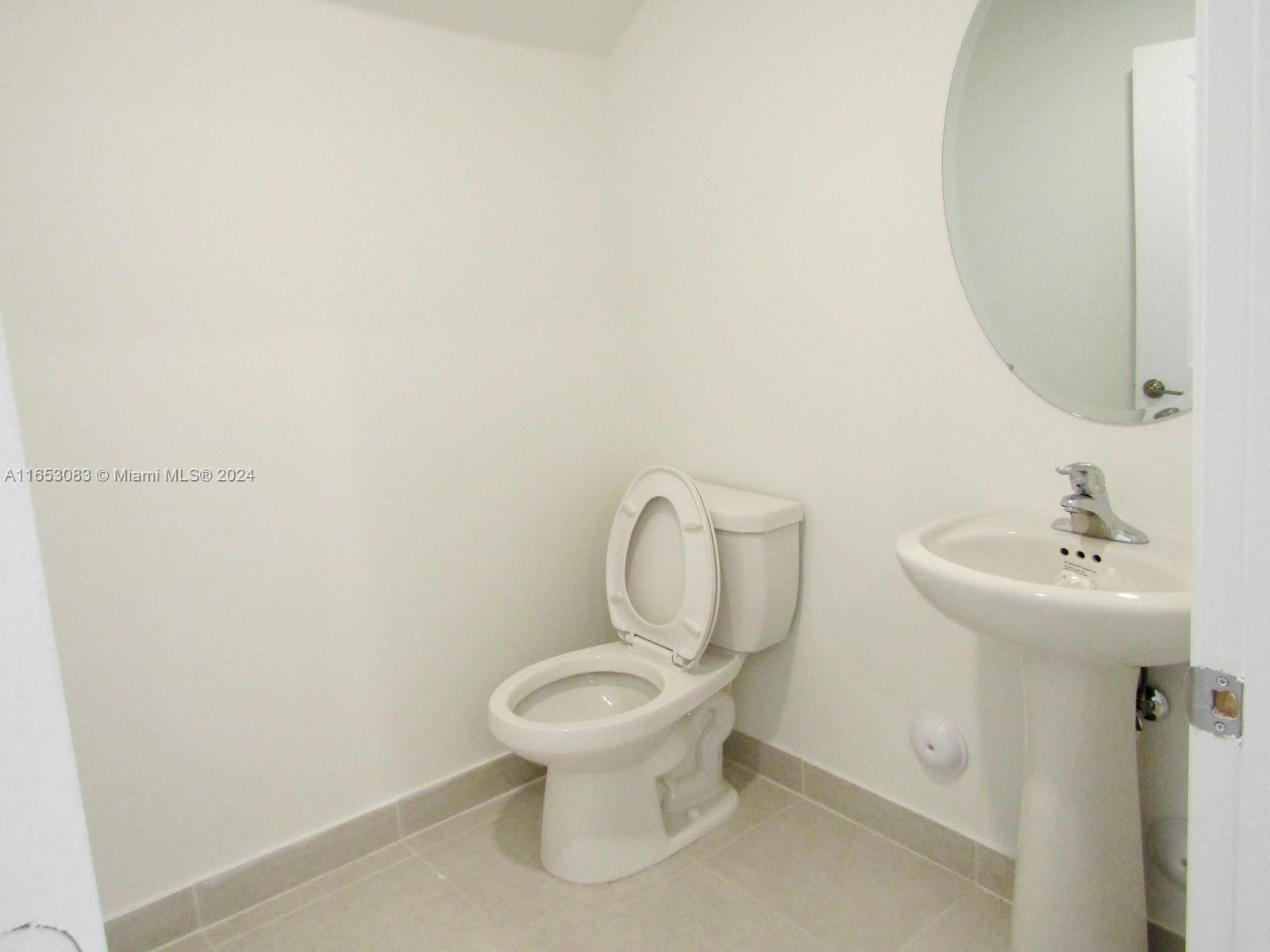 13401 Southwest 287th Street, Unit 13401 Homestead, FL 33033 - Photo 24 of 29 a white toilet sitting next to a bathroom sink