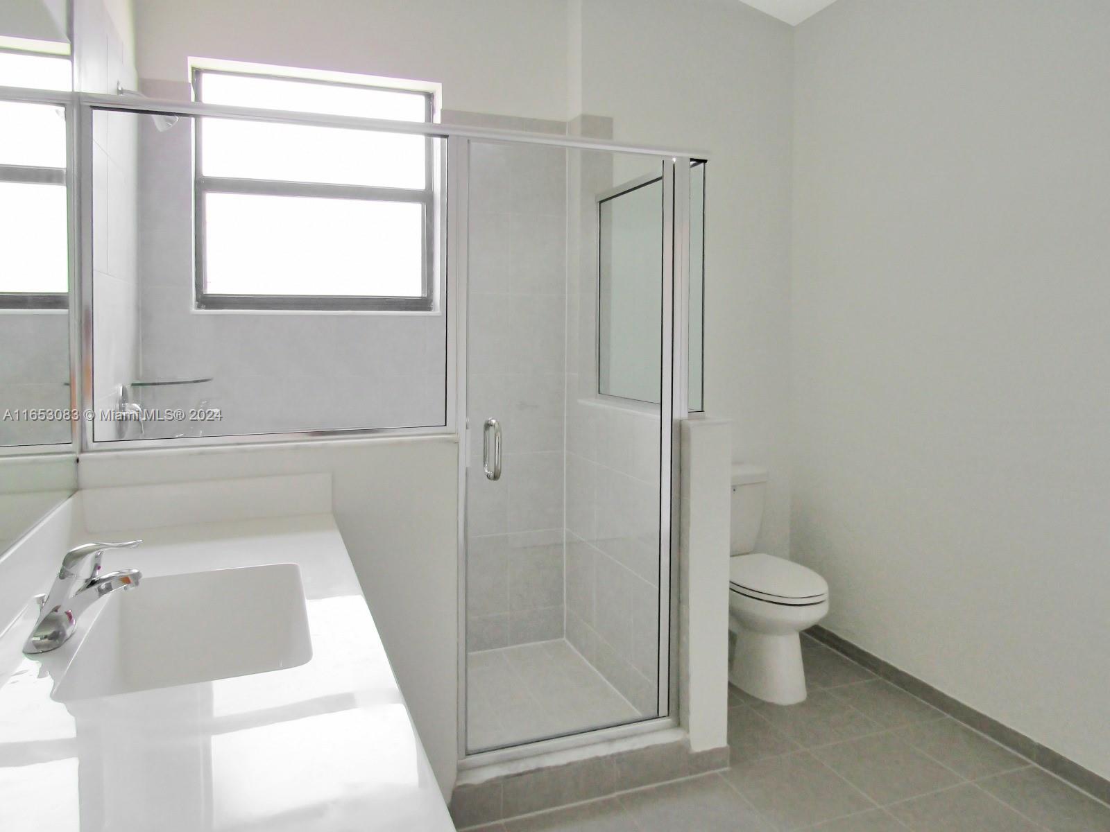 13401 Southwest 287th Street, Unit 13401 Homestead, FL 33033 - Photo 25 of 29 a bathroom with a sink toilet and shower