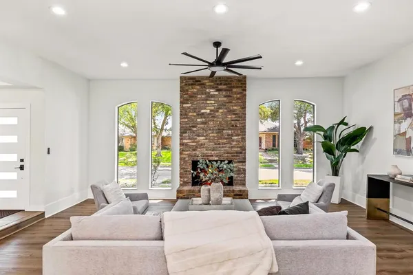 a living room with fireplace furniture and a large window